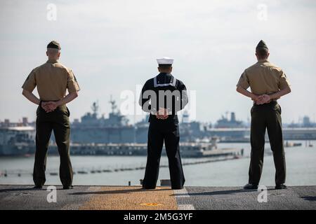 NORFOLK, Virginia – Matrosen und Marines bewachen die Schienen, während das amphibische Sturmschiff USS Kearsarge (LHD 3) der Wasp-Klasse am 16. März 2022 von der Naval Station Norfolk abfährt. Die Kearsarge Amphibious Ready Group (ARG) und die 22. Marine Expeditionary Unit (MEU) sind im Atlantik tätig, um Marineeinsätze zu unterstützen, um die Stabilität und Sicherheit des Seeverkehrs zu gewährleisten, den Zugang zu gewährleisten, Aggressionen abzuwehren und die Interessen der USA, Verbündeten und Partner zu verteidigen. Stockfoto