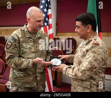 Major General Wendul Hagler, der stellvertretende kommandierende General der USA Army Central Command, überreicht Brig ein Geschenk. Gen. Fahad Al-Otaibi, Direktor des Kuwait-Büros für militärische Zusammenarbeit, Kuwait-Armee, zum Abschluss der zweijährlichen Überprüfung des Project Financial Management 7. im Verteidigungsministerium Kuwaits, Kuwait-Stadt, am 16. März 2022. Stockfoto