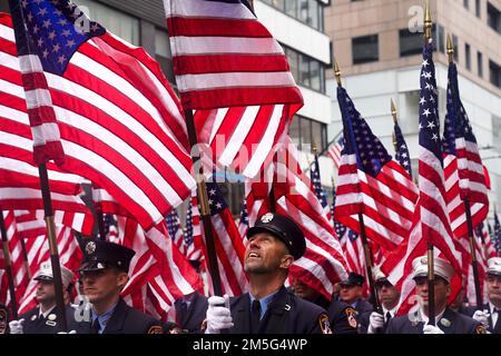 Die Polizei vom New York City Police Department hält die US-Flagge, während sie während der New York City Street marschiert Patrick's Day Parade in New York, 17. März 2022. Die NYC St. Patrick's Day Parade findet jedes Jahr an der Fifth Avenue statt, um das irische Erbe zu feiern, an diejenigen zu erinnern, die während der Terroranschläge vom 11. September 2001 starben, und um Ersthelfer und wichtige Arbeiter zu feiern. Stockfoto