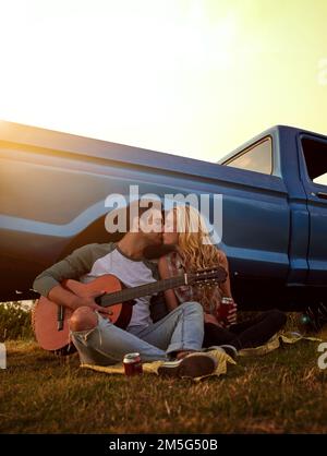 Er hat ihr Herz für sich gewonnen. Ein junger Mann, der Gitarre für seine Freundin spielt. Stockfoto