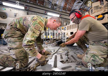 USA Die dem 386. Geschwader zur Vorbereitung der Expeditionslogistik zugeteilten Luftwaffensoldaten sichern sich einen Militärhumvee, der dem 1-153. Kavallerie-Regiment zugeteilt ist, im Frachtraum eines C-17 Globemaster III, der dem 816. EAS während der Operation Agile Spartan II am Luftwaffenstützpunkt Ali Al Salem, Kuwait, 16. März 2022 zugeteilt wurde. Die Mitglieder nahmen an der Operation Agile Spartan (OAS) II Teil, einer groß angelegten, gemeinsamen und multinationalen Operation, die sich auf operative Tests und Evaluierung der Kernkompetenzen von Agile Combat Employment konzentrierte. Stockfoto