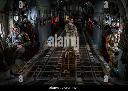 Von links, Air Force Tech. Sgt. Radek Kret, Air Force Staff Sgt. Jacob Thomas, und Airman 1. Klasse Brian Elliot, übernehmen die Aufgaben des Lastmeisters während einer Ausbildungsmission an Bord eines C-130H-Flugzeugs, 17. März 2022, East Granby, Conn Loadmasters überwachen das Flugzeug, scannen nach Bedrohungen und sind verantwortlich für das ordnungsgemäße Laden und Sichern der Fracht für die Abwurfstellen. Stockfoto