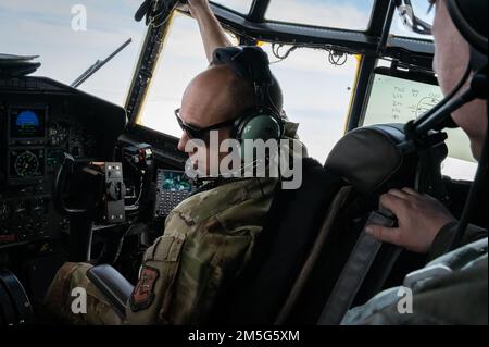 Oberstleutnant Matthew Deardorff, Pilot des 103. Luftschubflügels, kommuniziert mit Air Force Master Sgt. Brian Sheldon, einem Flugingenieur des 103., während einer Ausbildungsmission, 17. März 2022, East Granby, Conn., ein C-130H-Herkules-Flugzeug begleitet Die C-130 ist das wichtigste Transportmittel für die Luftabwurf von Truppen und Ausrüstung in feindliche Gebiete. Stockfoto