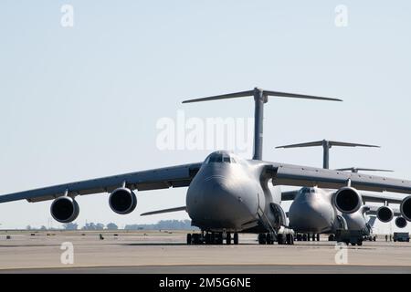 Mehrere C-5M Super-Galaxy-Flugzeuge sitzen auf der Fluglinie am Luftwaffenstützpunkt Travis, Kalifornien, 16. März 2022. Der C-5M mit einer Fracht von 281.001 Pfund (127.460 Kilogramm) kann 2.150 Seemeilen fliegen, entladen und zu einer zweiten Basis fliegen, die 500 Seemeilen vom ursprünglichen Ziel entfernt ist – alles ohne Betanken aus der Luft. Beim Betanken aus der Luft ist die Reichweite des Flugzeugs nur durch die Ausdauer der Besatzung begrenzt. Stockfoto