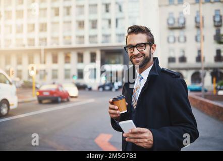 Kaffee, Konnektivität und Klasse, unverzichtbar für einen Stadtmenschen. Ein stilvoller Mann mit Kaffee und Telefon in der Hand, während er in der Stadt ist. Stockfoto