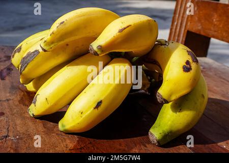 Ein Haufen reifer Bananen auf dem Holzstuhl. Stockfoto