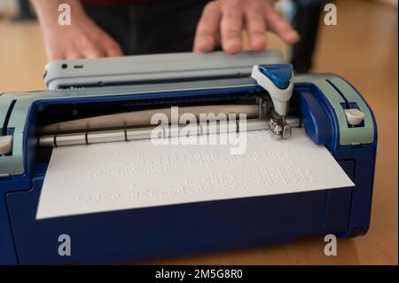 Blinder Mann mit Brailleschrift-Schreibmaschine. Stockfoto