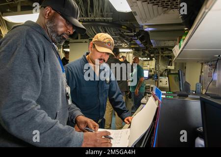 Von links arbeitet das Wartungsteam Logistiker Ronald Billups mit Petty Officer 3. Class Gabriel Soto zusammen, um die Validierung der Wartungsanforderungskarten in einem der Radarräume an Bord der USS Anchorage (LPD 23) durchzuführen, während sie im Hafen des Naval Surface Warfare Center, Port Hueneme Division, Für Combat Systems Assessment und Training am 16. März. Stockfoto