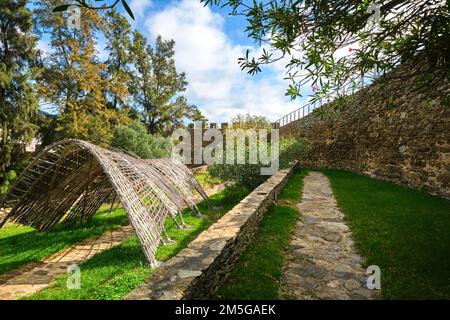 Blick auf den Innenhof mit Rasen und moderner Skulptur im Holzbogen-Schatten. Am Castelo de Alcoutim in der Algarve von Portugal, westlich Stockfoto