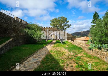 Blick auf den Innenhof mit Rasen und moderner Skulptur im Holzbogen-Schatten. Am Castelo de Alcoutim in der Algarve von Portugal, westlich Stockfoto