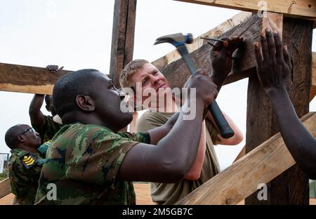 Mitglieder der Ingenieurbrigade der Ruanda-Streitkräfte arbeiten mit Soldaten der Wahoo-623.-Ingenieurgesellschaft der Nebraska Army zusammen, um im März 16 in Gako, Ruanda, einen Wachturm zu bauen. (Foto der Nebraska Air National Guard von Oberstleutnant Kevin Hynes) Stockfoto