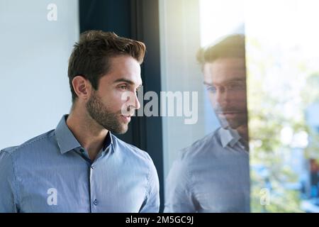 Gewidmet dem Job. Ein hübscher junger Geschäftsmann im Büro. Stockfoto