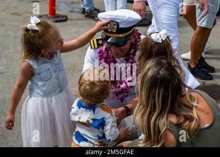 LT. Macklen Lethin aus Honolulu, Hawaii, dem Virginia-Klasse-Schnellangriff-U-Boot USS Minnesota (SSN 783) zugeteilt, trifft sich mit seinen Kindern auf den U-Boot-Piers an der Joint Base Pearl Harbor-Hickam, nachdem Minnesota einen Wechsel des Homeports von Groton, Connecticut, vollzogen hatte. Die Fähigkeit des U-Boots, eine Vielzahl von Missionen zu unterstützen, darunter U-Boot-Kampfführung, oberflächenabwehrende Kriegsführung, Streikkampfführung sowie Überwachung und Aufklärung, hat Minnesota zu einem der fähigsten und fortschrittlichsten U-Boote der Welt gemacht. Stockfoto