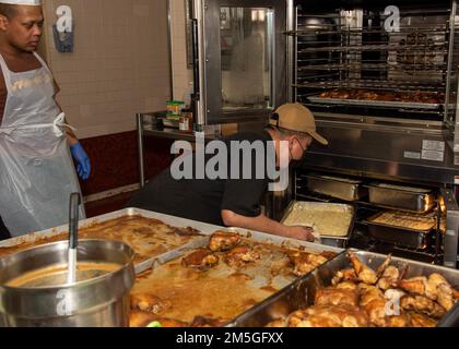 220317-N-DM318-1023 MARINEFLIEGER ATSUGI, Japan (17. März 2022) Chief Culinary Specialist Listerpaul Andrade entfernt Sheppard's Pie aus einem Ofen für einen St. Patrick's Day Spezialmahlzeit in der Far East Cafe Galley . Naval Air Facility (NAF) Atsugi unterstützt die Kampfbereitschaft von Commander, Carrier Air Wing FIVE (CVW 5), Helicopter Maritime Strike Squadron FIVE ONE (HSM-51) und 30 weiteren Mietern und bietet logistische Unterstützung, Koordination und Dienste für Einheiten, die dem westlichen Pazifik zugewiesen sind. Stockfoto