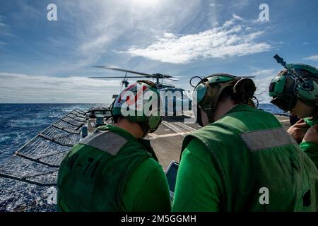 SEELEUTE DER PHILIPPINISCHEN SEE (17. März 2022), die den ‚Raptors‘ des Helicopter Maritime Strike Squadron (HSM) 71 zugeteilt sind, führen eine letzte Vorflugkontrolle durch, bevor sie einen MH-60R Sea Hawk Helikopter vom Cockpit des Arleigh-Burke-Klasse-Guided-Missile Destroyers USS Spruance (DDG 111) starten. Die Abraham Lincoln Strike Group befindet sich in einem geplanten Einsatz im US-7.-Flottenbereich, um die Interoperabilität durch Allianzen und Partnerschaften zu verbessern und gleichzeitig als einsatzbereite Truppe zur Unterstützung einer freien und offenen Region Indo-Pacific zu fungieren. Stockfoto