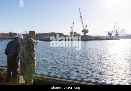 SILVERDALE, Washington (16. März 2022) – Ken Behal, Trident Refit Facility, Bangor’s (TRFB) Waterfront Buildings and Facilities Manager, diskutiert während seines Besuchs beim TRFB mit dem Program Executive Officer für strategische U-Boote, Rear ADM. Scott Pappano, den Zustand und die Fähigkeiten des Piers. Der Besuch von Pappano konzentrierte sich auf die Bemühungen, die alternden U-Boote für ballistische Raketen der Ohio-Klasse zu erhalten, und die Modernisierungsbemühungen, die in Erwartung des Baus der U-Boote für ballistische Raketen der Kolumbien-Klasse zu ihrer Ersetzung eingeleitet wurden. Die Kernaufgabe der TRFB besteht in der Reparatur, der schrittweisen Überholung und der Modernisierung Stockfoto