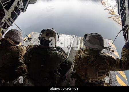 USA Justin Gowan und Royal Marine Commandos aus dem Vereinigten Königreich sitzen auf der Auffahrt eines CH-53E Super-Hengstes während der Exercise Cold Response 2022, Elvenes Airfield, Norwegen, 17. März 2022. Gowan ist ein Crewchef mit dem Helikopter-Geschwader 366. Die Royal Marine Commandos sind der Kommando-Helikopter-Truppe zugeteilt. Übung Cold Response ’22 ist eine alle zwei Jahre stattfindende Übung in ganz Norwegen, an der sich jeder seiner Militärdienste sowie 26 weitere alliierte Nationen und regionale Partner der Nordatlantikvertrags-Organisation beteiligen. Stockfoto