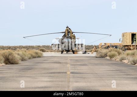 AH-64E Apache Helikopter-Mechaniker, 1-229. AngriffsBataillon, 16. Kampfluftfahrtbrigade, untersuchen einen Hubschrauber im Orchard Combat Training Center am 17. März 2022. Die Einheit führte Luftschusstische durch und trainierte mit den USA Air Force und Idaho Air National Guard. Stockfoto