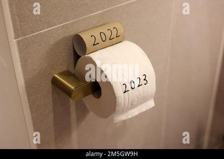 Toilettenpapiere, geschrieben als 2022 und 2023, was bedeutet, dass das alte Jahr gehen und das neue Jahr willkommen heißen Stockfoto