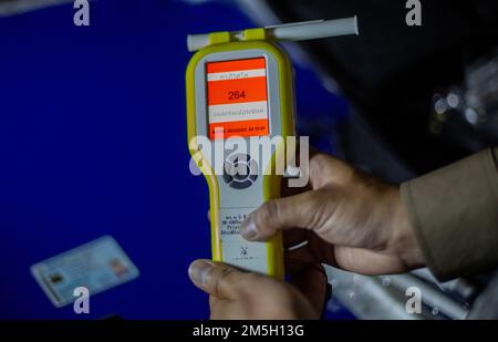 Ein thailändischer Polizist zeigt das Atemgerät mit einem höheren als normal für Alkoholtests am Check Point in Chiang Mai. Das Zentrum für Prävention und Reduzierung von Straßenverkehrsunfällen wurde während des Neujahrsfestivals 2023 eingerichtet, dem 7-tägigen intensiven Kontrollzeitraum vom 29. Dezember 2022 bis 4. Januar 2023. Mehr als 50.000 Polizeibeamte sollen Kontrollpunkte einrichten, um die Verkehrsgesetze zu vereinfachen und die Sicherheit der Menschen zu gewährleisten. Sie werden während des gesamten Festivals ohne Urlaub arbeiten und sich gemäß der Regierungspolitik auf 4 Gebühren konzentrieren: Fahren unter Alkoholeinfluss, Fahren zu schnell und nicht Stockfoto