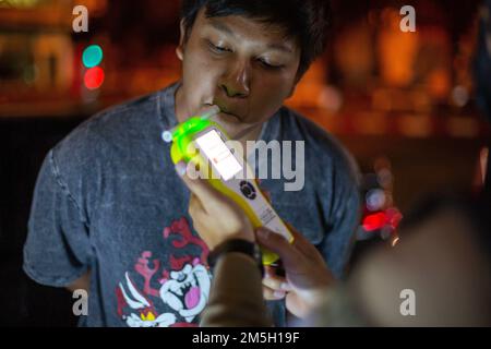 Ein thailändischer Polizist führt einen Fahrer durch einen Alkoholtest mit einem Atemgerät am Check Point in Chiang Mai. Das Zentrum für Prävention und Reduzierung von Straßenverkehrsunfällen wurde während des Neujahrsfestivals 2023 eingerichtet, dem 7-tägigen intensiven Kontrollzeitraum vom 29. Dezember 2022 bis 4. Januar 2023. Mehr als 50.000 Polizeibeamte sollen Kontrollpunkte einrichten, um die Verkehrsgesetze zu vereinfachen und die Sicherheit der Menschen zu gewährleisten. Sie werden während des gesamten Festivals ohne Urlaub arbeiten und sich gemäß der Regierungspolitik auf 4 Gebühren konzentrieren: Fahren unter Alkoholeinfluss, Fahren zu schnell und nicht tragen Stockfoto