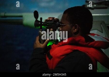 PHILIPPINE SEA (17. März 2022) Gunner's Mate 2. Class Taquan Taylor, aus Mobile, Alabama, mans the Mark 38 – 25 mm Maschinengewehr an Bord des Arleigh Burke-Class Guided-Missile Destroyer USS Dewey (DDG 105), während routinemäßige Operationen im Zuständigkeitsbereich der US-7.-Flotte durchgeführt werden. Dewey ist der Destroyer-Staffel (DESRON) 15 zugeteilt und unterstützt derzeit ein freies und offenes Indo-Pacific. CTF 71/DESRON 15 ist die größte nach vorn verlegte DESRON-Flotte der Marine und die größte Oberflächenkraft der US-7.-Flotte. Stockfoto