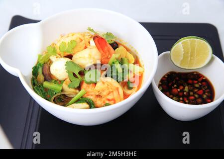 cinese Seafood Shrimp Curry Portion in der Schüssel, serviert mit Wachtelei Gemüse Limette Chili in Sojasoße Stockfoto