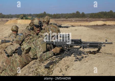 Ein Assistant Gunner ruft Befehle an seinen M240. Gunner, während er während einer kombinierten Feuerübung mit Fallschirmjägern, die dem 1. Bataillon, 505. Fallschirm-Infanterie-Regiment, 3. Brigaden-Kampfteam, 82. Luftwaffe und polnischen Soldaten mit der 19. Mechanisierten Brigade zugeteilt wurden, Ziele angreift. Das 3. Brigaden-Kampfteam, 82. Luftwaffe, ist in Polen stationiert, um unsere Alliierten zu versichern und die NATO-Allianz zu stärken. Stockfoto