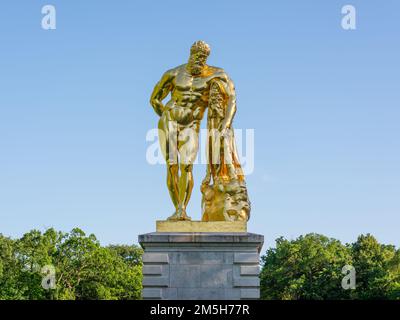 Maincy, Frankreich - 21. Mai 2022: Nahaufnahme einer goldgrünen Skulptur, die eine Kopie eines Hellenistischen Epochen Herkules in einer klassischen französischen Ga darstellt Stockfoto