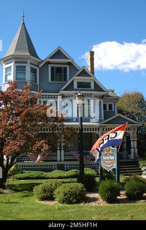 Amish Country Byway - Victorian House and Museum. Hinter den grünen Sträuchern und dem Rasen befindet sich das Victorian House and Museum. Die 28 Zimmer sind mit verschiedenen Themen gestaltet: Es gibt Rechts- und Arztpraxen aus der Jahrhundertwende, ein Kinderzimmer mit antikem Spielzeug, ein Zimmer mit Artefakten aus dem Bürgerkrieg, ein Nähzimmer mit viktorianischen Kleidern und ein weiteres Zimmer mit einer großen Auswahl an frühen Musikinstrumenten. Standort: Millersburg, Ohio (40,554° N 81,917° W) Stockfoto