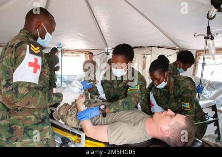 Sanitäter des Medizinischen Korps der ruandischen Verteidigungskräfte behandeln einen Patienten - in diesem Fall einen Freiwilligen der Nebraska Army National Guard - in einem Level-2-Krankenhaus der Vereinten Nationen während einer medizinischen/technischen Übung in Gako, Ruanda, im März. Die Übung ermöglichte es Mitgliedern der ruandischen Verteidigungskräfte und der Nationalgarde Nebraska, im Rahmen des National Guard's State Partnership Program zusammenzuarbeiten. (Foto der Nebraska Air National Guard von Oberstleutnant Kevin Hynes) Stockfoto