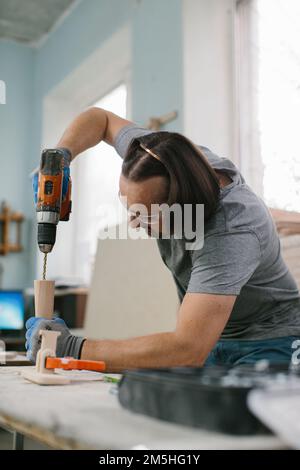 Tischler Bohrer ein Loch mit einer elektrischen Bohrmaschine Stockfoto