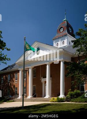 Harriet Tubman Underground Railroad Byway - Caroline County Courthouse Mit Kolonialem Chesapeake-Charme. An einem wolkenlosen Sommertag weht eine Flagge vor den beeindruckenden weißen Säulen des Caroline County Courthouse. Caroline County Courthouse Square, Denton, Maryland Stockfoto