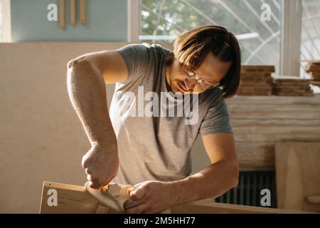 Ein Zimmermann stellt in seiner Werkstatt ein Kletterset Montessori für Kinder her. Stockfoto