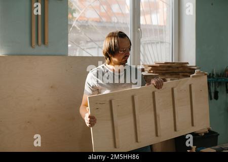 Ein Zimmermann stellt in seiner Werkstatt ein Kletterset Montessori für Kinder her. Stockfoto