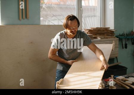 Ein Zimmermann stellt in seiner Werkstatt ein Kletterset Montessori für Kinder her. Stockfoto