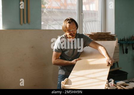 Ein Zimmermann stellt in seiner Werkstatt ein Kletterset Montessori für Kinder her. Stockfoto