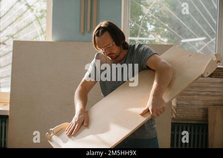 Ein Zimmermann stellt in seiner Werkstatt ein Kletterset Montessori für Kinder her. Stockfoto