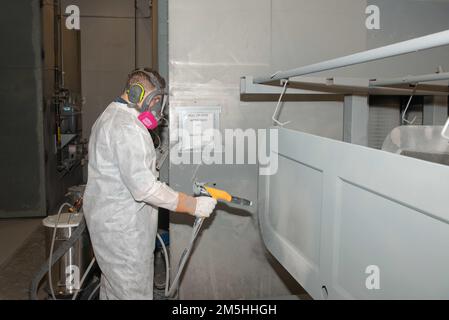 USA Navy Aviation Boatswain’s Mate (Handling) Airman Harley Ambrowsky aus Hopson, Florida, dem Flugzeugträger USS John C. Stennis (CVN 74) zugewiesen, spritzt ein elektrisch geladenes Trockenpulver auf eine nicht wasserdichte Tür in der Leichtindustriefazilität in Newport News, Virginia, 18. März 2022. John C. Stennis arbeitet in Newport News Shipyard zusammen mit NNS, NAVSEA und Auftragnehmern, die im Rahmen der Mission, das Kriegsschiff rechtzeitig und im Rahmen des Budgets wieder in den Kampf zurückzubringen, ihre Pflicht zur Verteidigung der Vereinigten Staaten wiederaufnehmen. Stockfoto