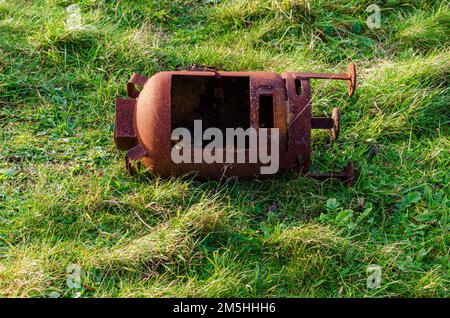 Alter verrosteter Holzbrenner, der am Rande des Grases im Tyrella Beach County in Nordirland entsorgt wurde Stockfoto