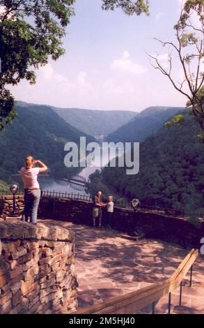 Midland Trail - Besucher am Hawk's Nest Overlook. Der Aussichtspunkt From Hawk's Nest Overlook bietet eine atemberaubende Kulisse für Fotos, wie Besucher in diesem Bild belegen. Standort: West Virginia Stockfoto