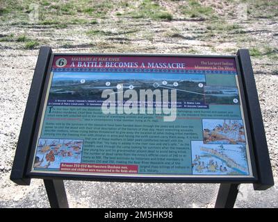 Pioneer Historic Byway - Hinweisschild am Bear River Massacre Site: „Eine Schlacht wird zu einem Massaker“. Dieses Zeichen zeigt die schrecklichen und erschütternden Ereignisse des Massakers. Farbige Skizzen zeigen Teepees, die brennen, Soldaten feuern und Soldaten auf dem Pferderücken in das Lager reiten. Lage: Bear River Massacre Overlook, nahe Preston, Idaho (42,151° N 111,908° W) Stockfoto