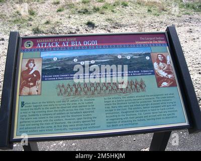 Pioneer Historic Byway - Hinweisschild am Bear River Massacre Site: „Attack at Bia Ogoi“. Dieses Schild beschreibt den bitterkalten Tag des 29. Januar 1863, an dem das größte indische Massaker im Westen stattfand. Auf diesem Schild befinden sich historische Fotos eines Armeemanns und eines Shoschonen sowie eine Karte mit den Orten der Hauptparteien des Massakers. Ort: Bear River Massacre Overlook, Idaho (42,151° N 111,908° W) Stockfoto