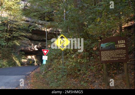 Red River Gorge Scenic Byway - Wegweiser am Nada Tunnel. Der westliche Eingang zum Nada-Tunnel ist mit vielen Schildern markiert. Der Reisende wird darüber informiert, dass der Tunnel 12 Meter hoch ist, er soll warten, bis der entgegenkommende Verkehr den Tunnel verlässt, bevor er weiterfährt, und er wird auch über die Geschichte des Tunnels informiert. Lage: Nada Tunnel, Kentucky Stockfoto