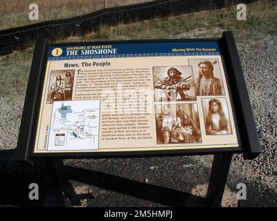 Pioneer Historic Byway - Hinweisschild am Bear River Massacre Site: „The Shoshone, Moving with the Seasons“. Die Shoschonen zogen mit den Jahreszeiten um und lebten in großen Familien. Die Nachfahren der Band, die am Bear River massakriert wurden, leben im Nordosten von Utah und im Südosten von Idaho. Dieses Schild informiert darüber und zeigt historische Bilder von Shoshone-Indianern in Sepiatönen. Auf dem Schild befindet sich auch eine Karte. Ort: Bear River Massacre Overlook, Idaho (42,151° N 111,908° W) Stockfoto