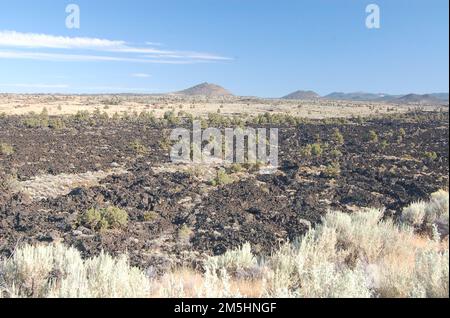Volcanic Legacy Scenic Byway - Lava fließt am Devil's Homestead. Schwarze Lava bildet den treffend benannten Bereich „Devil's Homestead“ des Lava Beds National Monument. Lage: Lava Beds National Monument, Kalifornien (41,793° N 121,562° W) Stockfoto