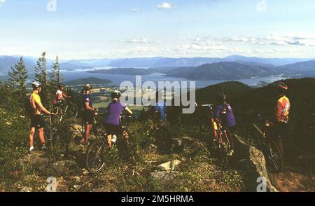 Mountainbike-Touren in Schweitzer. Mountainbiker genießen einen Panoramablick auf Lake Pend Oreille und die Selkirk Mountains im Schweitzer Mountain Resort, dem größten Ski- und Sommerresort im Nordwesten des Landes. Fahrten mit dem Sessellift und Mountainbike-Strecken bieten Sommerspaß. Idaho (48,319° N 116,623° W) Stockfoto