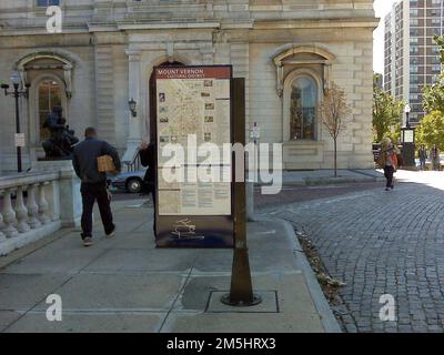 Baltimore's Historic Charles Street - Charles Street Wayfinding Schild. Informative Schilder und Wegweiser im Mount Vernon Place National Landmark District ragen aus kopfsteingepflasterten Straßen gegenüber dem Peabody Institute and Library. Lage: Baltimore, Maryland Stockfoto