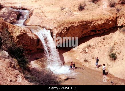 Scenic Byway 12 - Waten im Tropic Creek Waterfall. Eine Familie genießt das kühle Wasser am Fuße eines Wasserfalls auf dem Mossy Cave Trail (dem Wasserfallzweig der Wanderung). Standort: Utah (37,664° N 112,114° W) Stockfoto