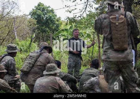 USA Army Staff Sergeant Jarrod Withrow, Dschungellehrer der Lightning Academy, 25. Infanterieabteilung, spricht mit den USA Soldaten des 2. Bataillons, 27. Infanterie-Regiment, 3. Infanterie-Brigaden-Kampfteam, 25. Infanterie-Division, Und philippinische Soldaten des 1. Brigaden-Kampfteams während eines Kurses über die Verfolgung im Rahmen des Trainingskurses für Dschungeloperationen, durchgeführt in Salaknib 2022 in Fort Magsaysay, Nueva Ecija, Philippinen, 18. März 2022. Der Ausbildungslehrgang für den Dschungelbetrieb war eine der vielen Ausbildungsveranstaltungen, die während des Salaknib 2022 abgehalten wurden, um den kombinierten Harnstoffgehalt zu erhöhen Stockfoto